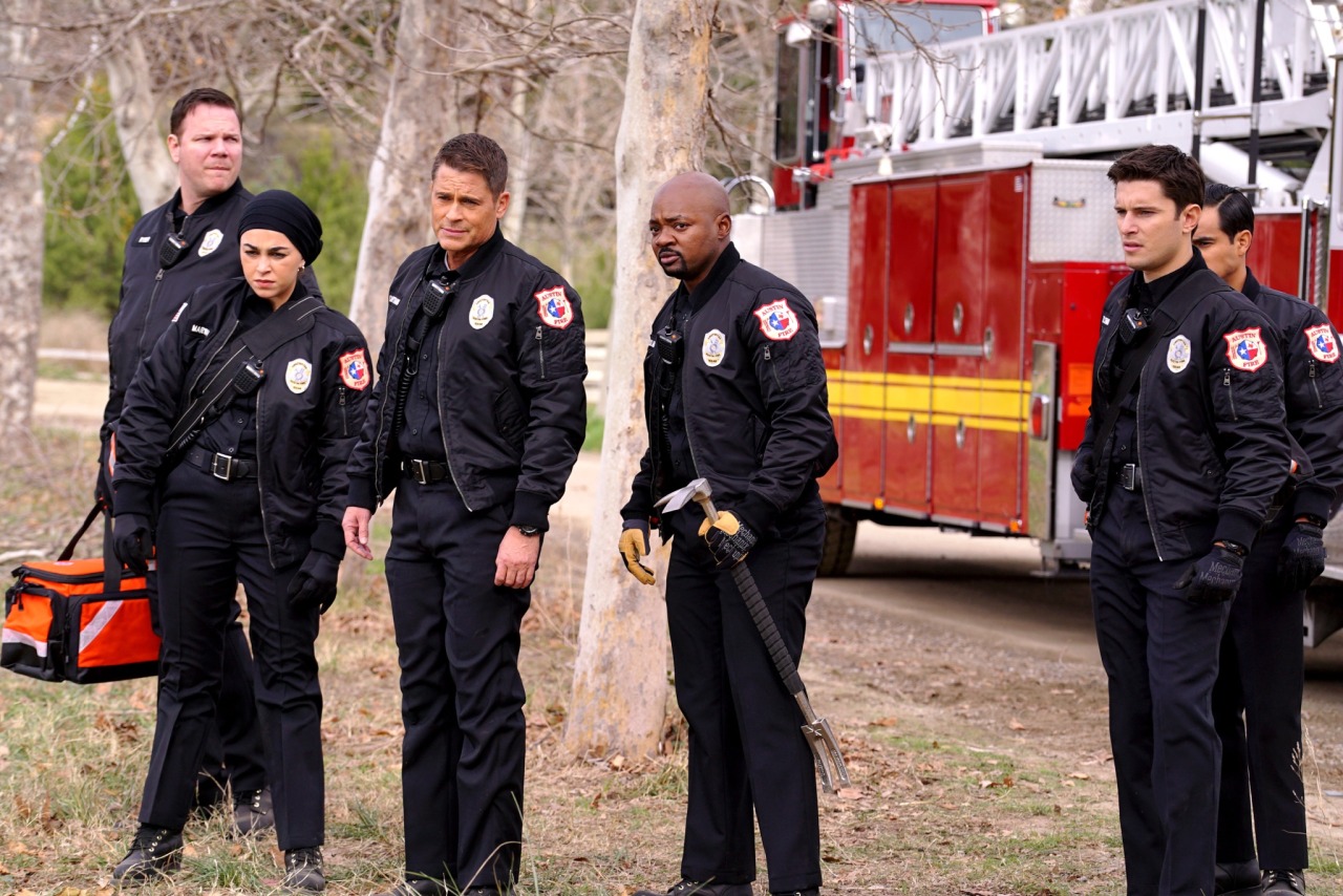 The cast of 911: Lone Star standing in front of a firetruck.
