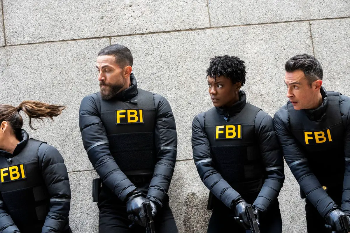 The FBI cast in Kevlar vests against a grey wall