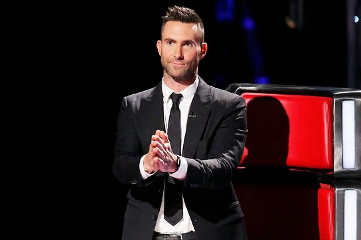 Maroon 5's Adam Levine stands in a suit on The Voice.
