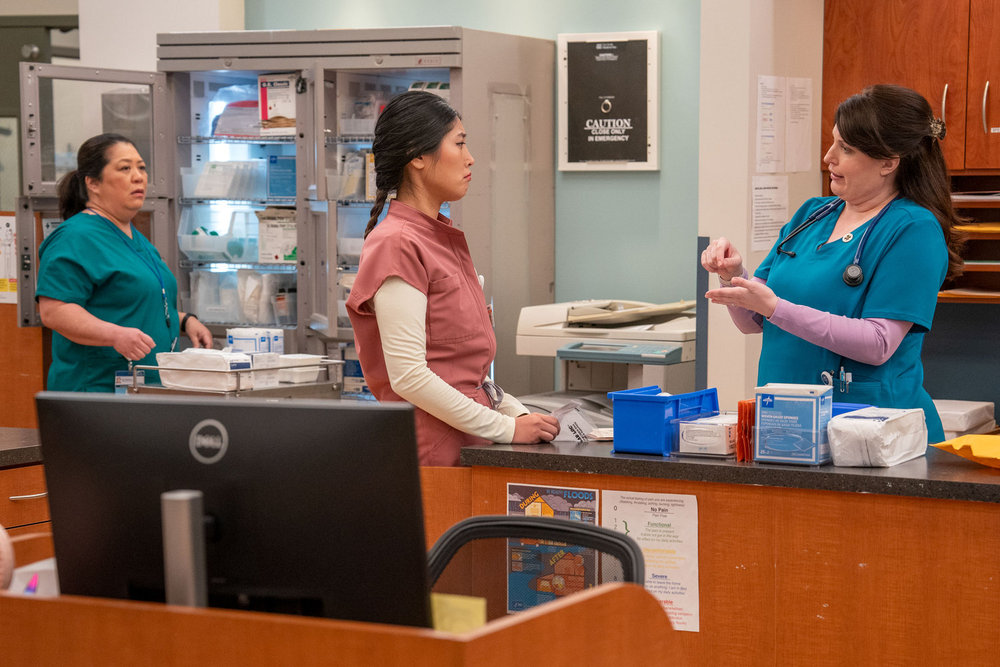 ST. DENIS MEDICAL -- "Office Romance" Episode 108 -- Pictured: (l-r) Kaliko Kauahi as Val, Kahyun Kim as Serena, Allison Tolman as Alex -- (Photo by: Ron Batzdorff/NBC)